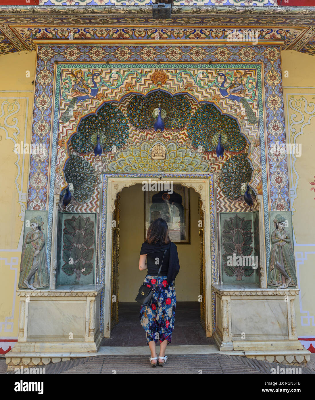 A young woman visit the colorful gate of Pritam Niwas Chowk of City Palace in Jaipur, India. Stock Photo