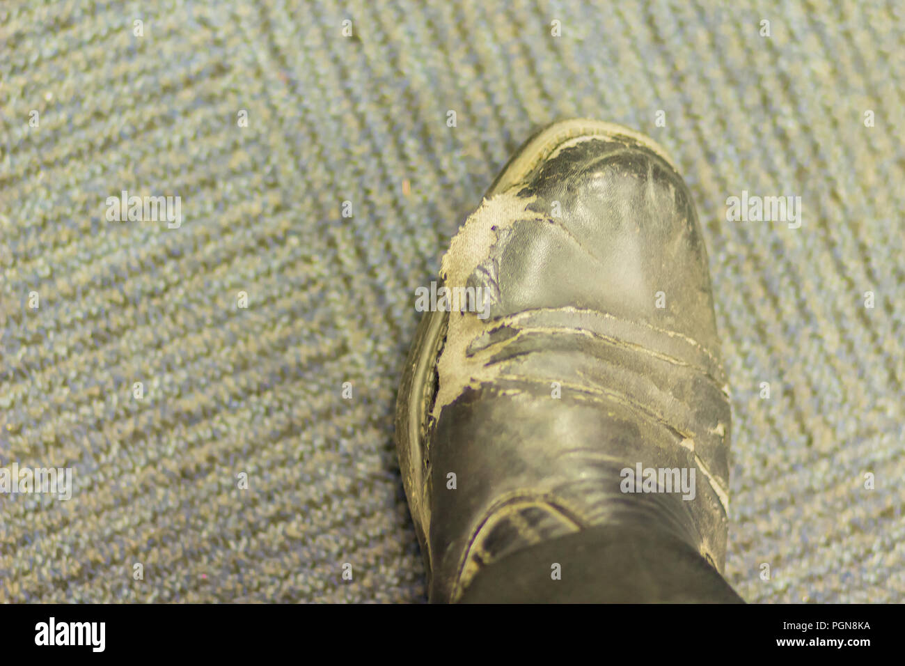 Closeup view of wear and tear office man's black leather shoes. Old