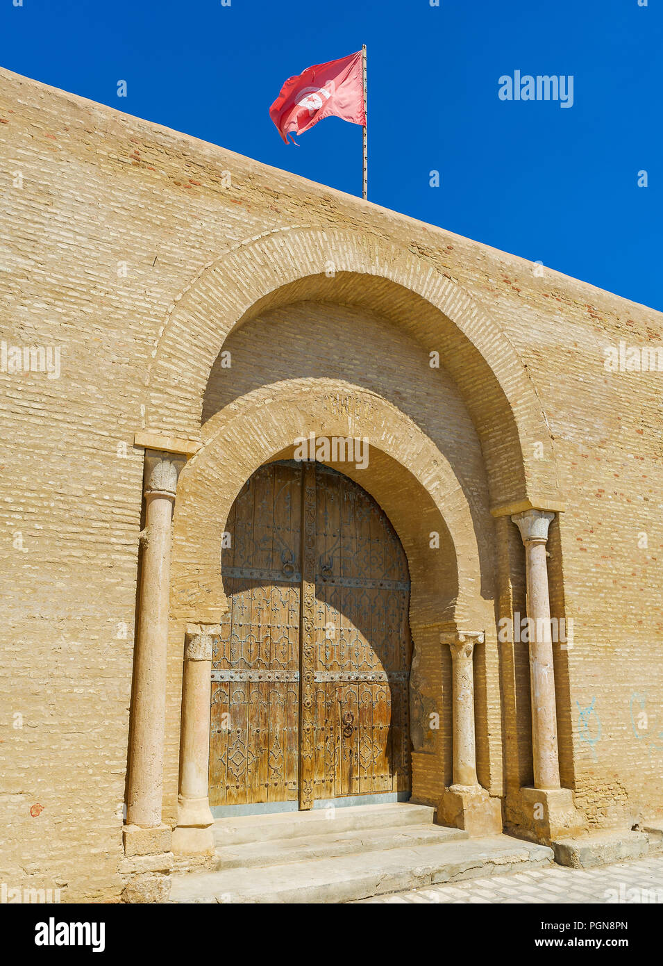 The double horseshoe gate of Zaouia of Sidi Amor Abbada - historical complex with medieval mausoleum and historical museum, Kairouan, Tunisia. Stock Photo