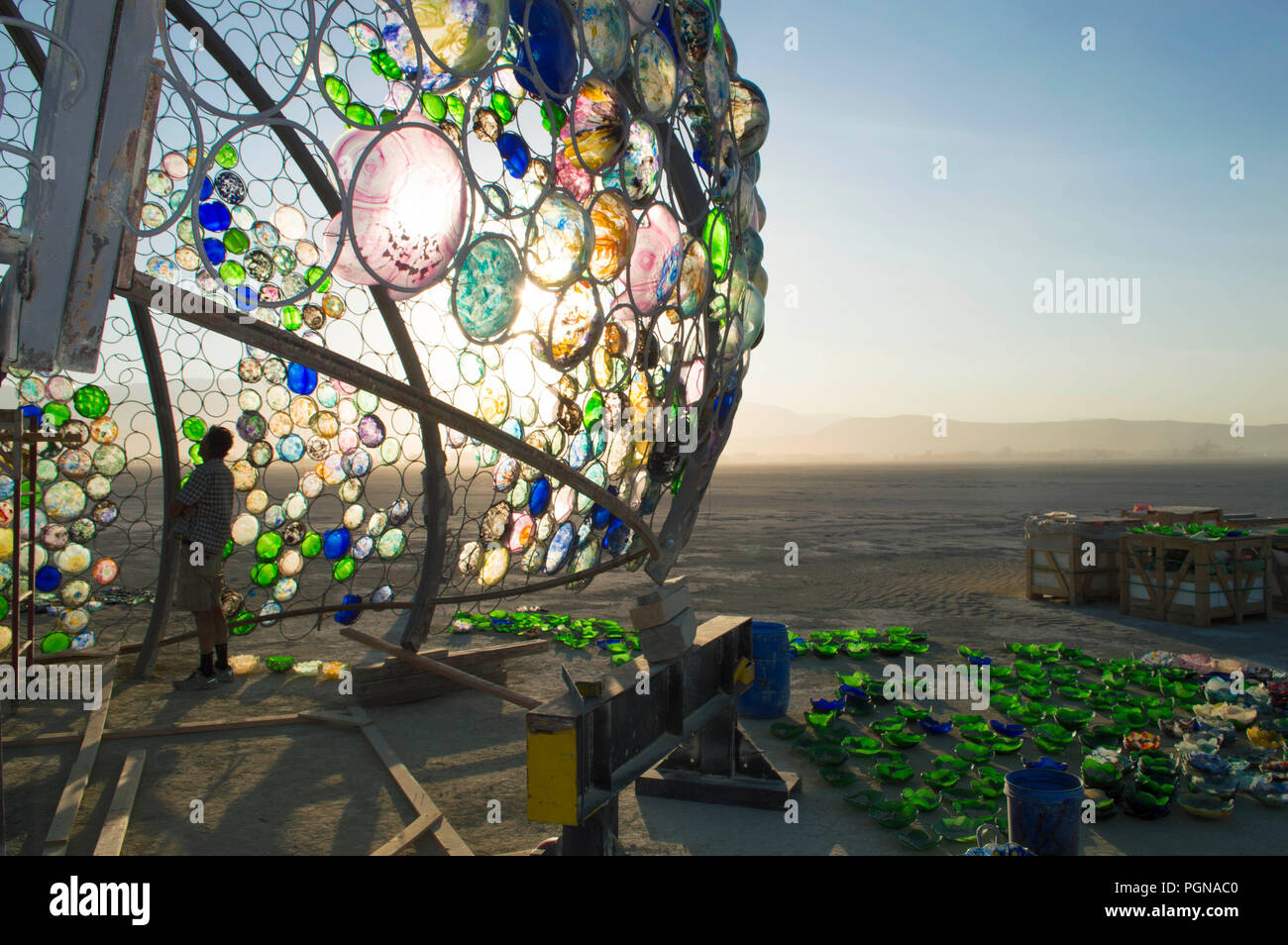 Workers assembly hundreds of hand made stained glass inserts that will eventually be illuminated by lights for the Jelly Fish Project at the Burning Man Festival as they prepare for attendees to the annual counter culture festival in the desert August 23, 2018 near Black Rock, Nevada. Each year 80,000 of people set up a temporary art city in the middle of the desert. Stock Photo