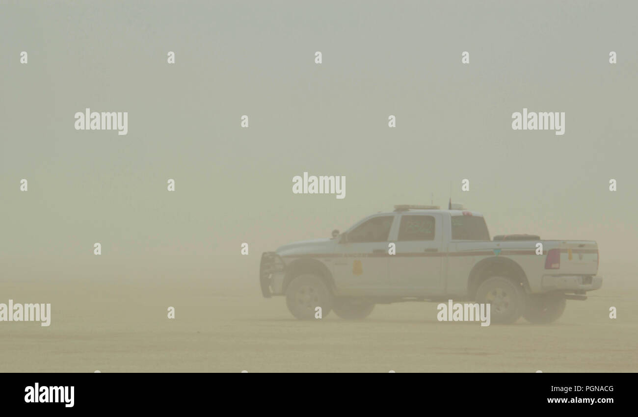 A Bureau of Land Management law enforcement truck waits out a dust storm during preparations for the annual Burning Man counter culture festival in the desert August 22, 2018 near Black Rock, Nevada. Each year 80,000 of people set up a temporary art city in the middle of the desert. Stock Photo