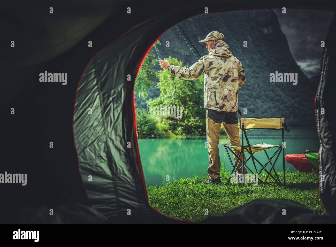 Fishing Camping Weekend. Caucasian Fisherman in Front of His Tent. Stock Photo