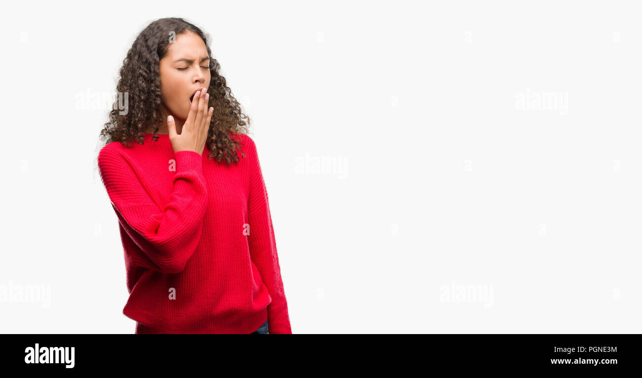 Young hispanic woman wearing red sweater bored yawning tired covering mouth with hand. Restless and sleepiness. Stock Photo