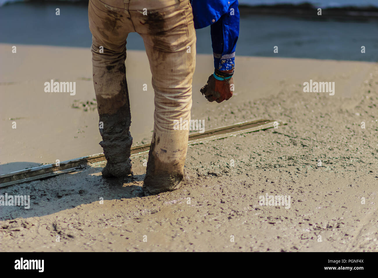 Masonry Worker Is Using Long Trowel To Smooth Or Leveling Concrete