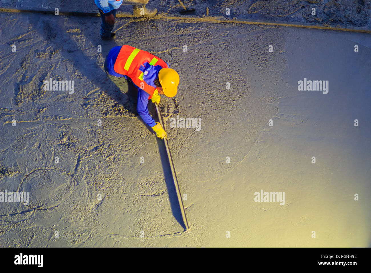 Mason worker leveling concrete with trowels, mason hands spreading poured concrete. Concreting