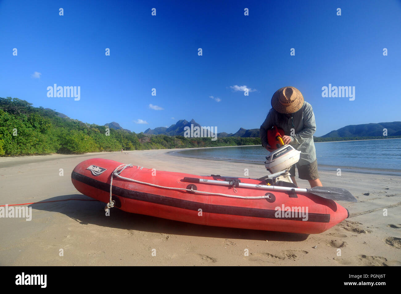 Refueling outboard on small inflatable boat, Zoe Bay, Hinchinbrook Island National Park, Queensland, Australia. NO MR or PR Stock Photo