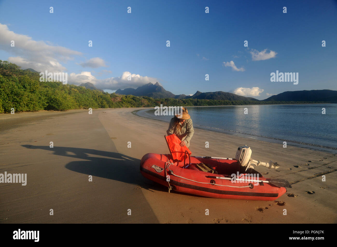 Man with red inflatable boat on remote beach, Zoe Bay, Hinchinbrook Island National Park, Queensland, Australia. NO MR or PR Stock Photo