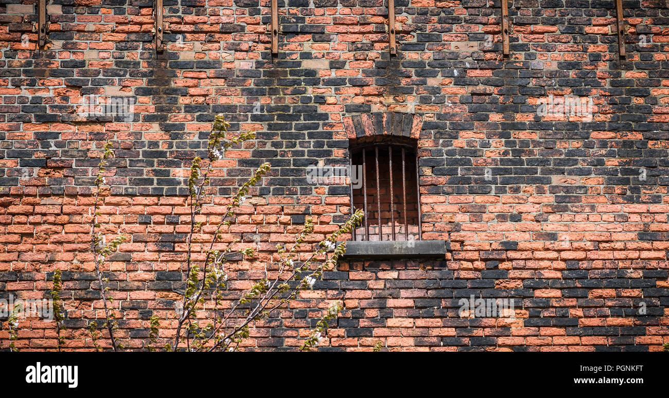 Old rusty barred window on a Victorian brick warehouse. Stock Photo
