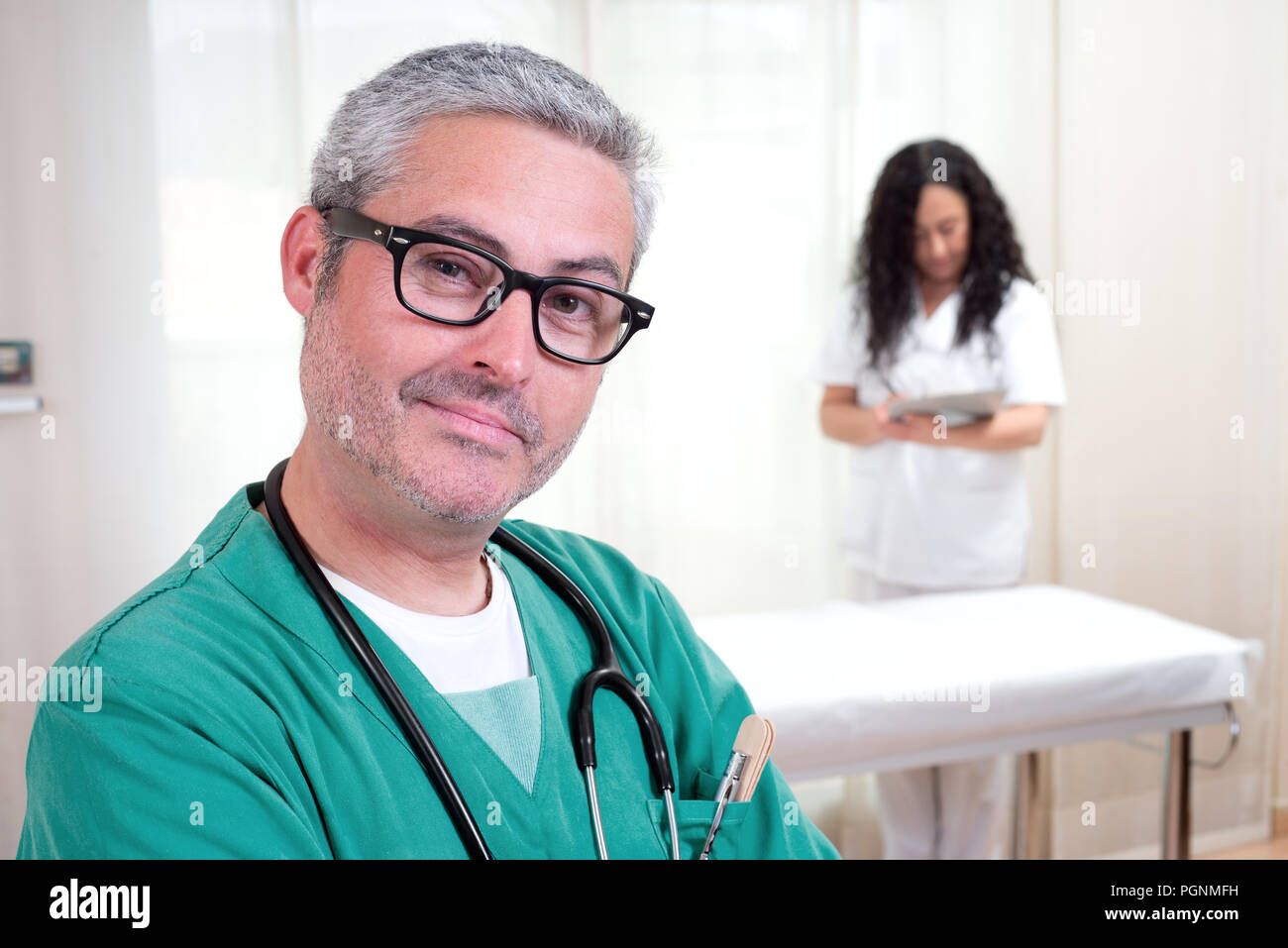 doctor looking at camera and nurse working Stock Photo - Alamy