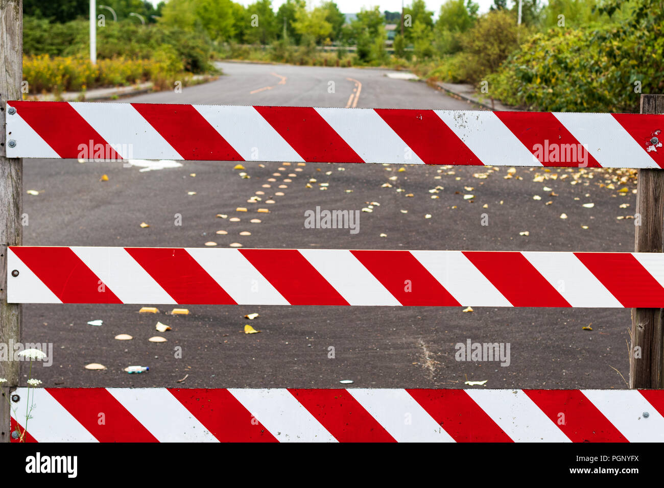 Road block barricade sign stripes white and red with road behind Stock Photo