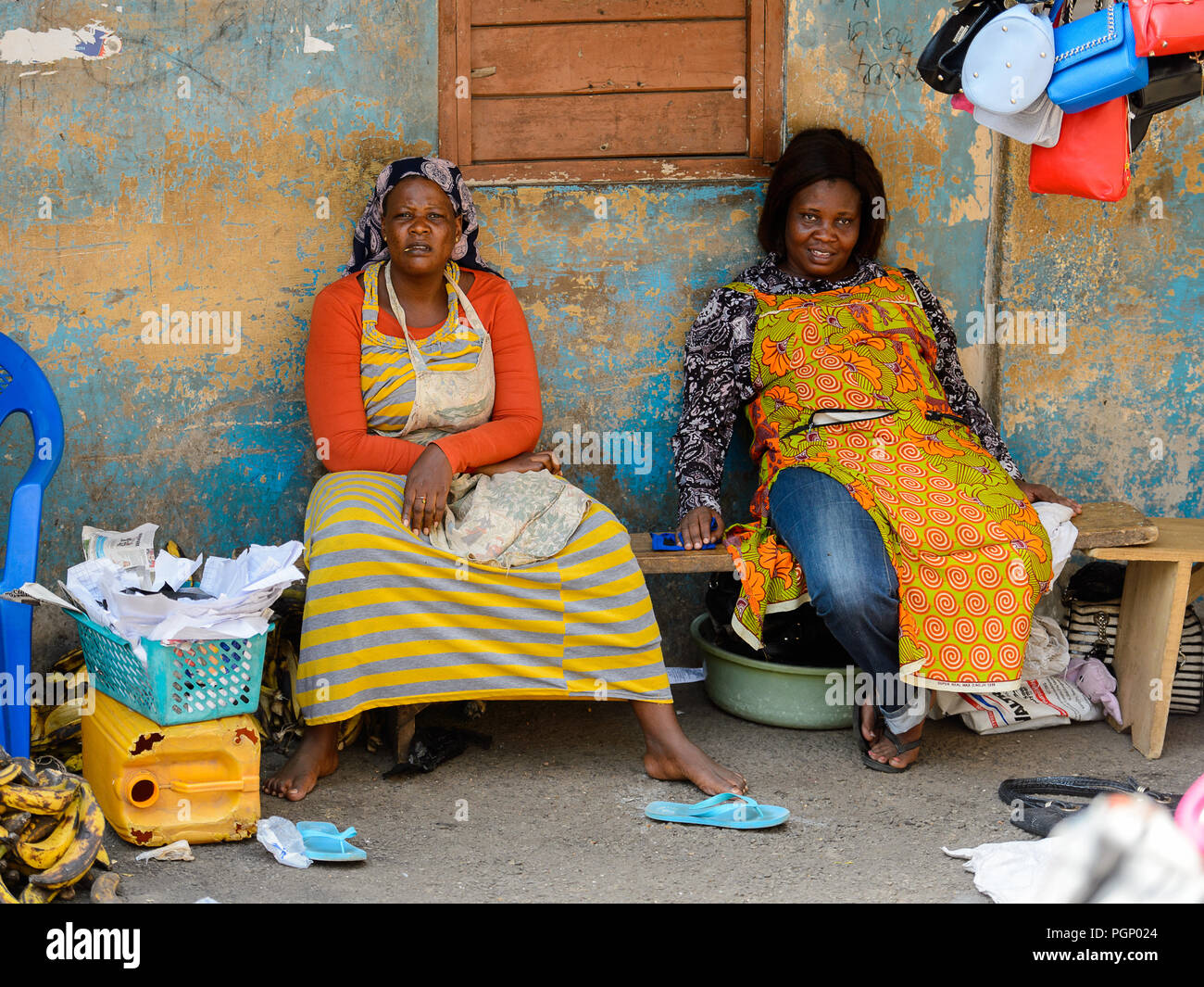 KUMASI, GHANA - JAN 15, 2017: Unidentified Ghanaian women in colored clothes  sit on the bench at the Kumasi market. Ghana people suffer of poverty due  Stock Photo - Alamy