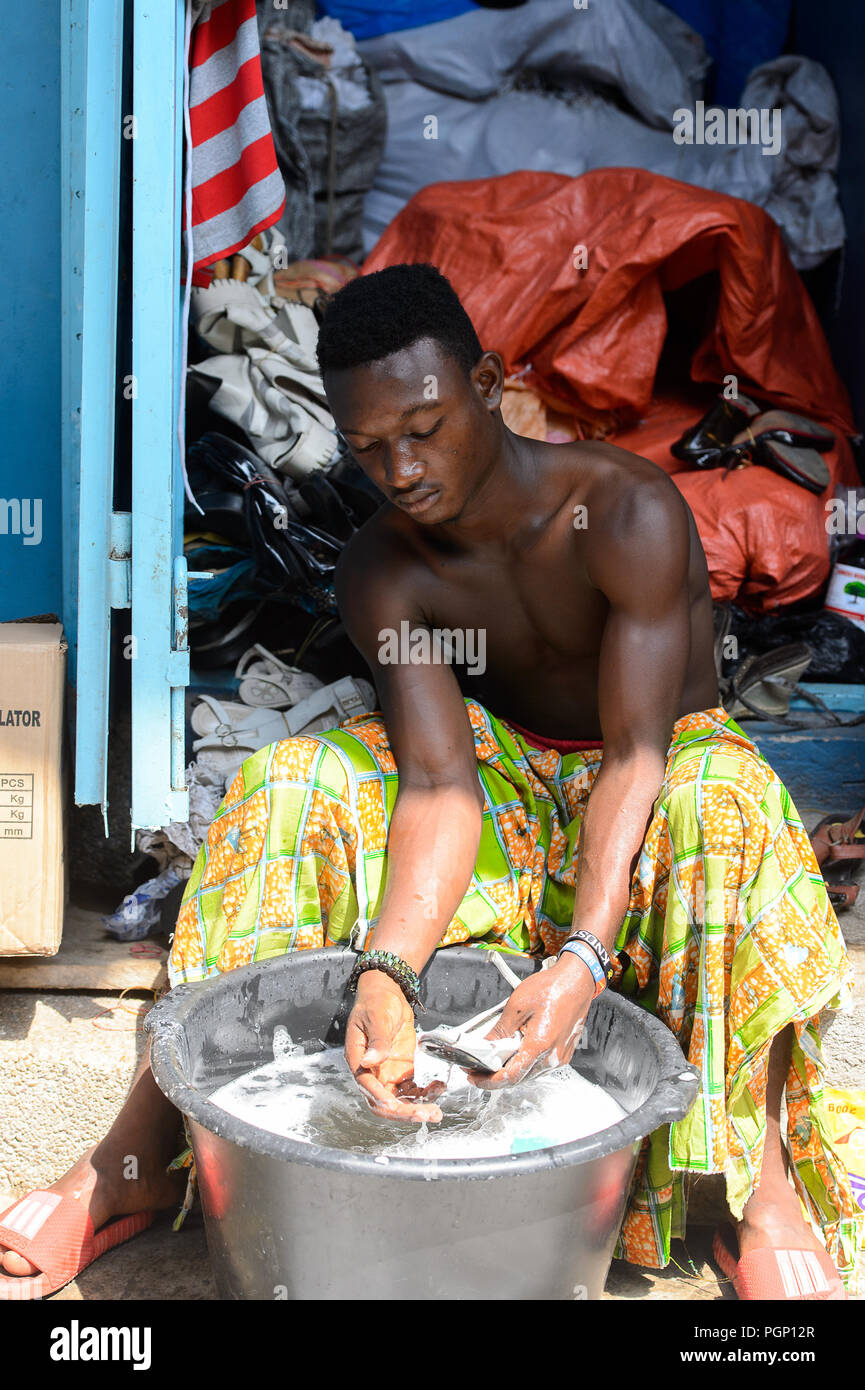 KUMASI, GHANA JAN 15, 2017 Unidentified Ghanaian man washes a shoe