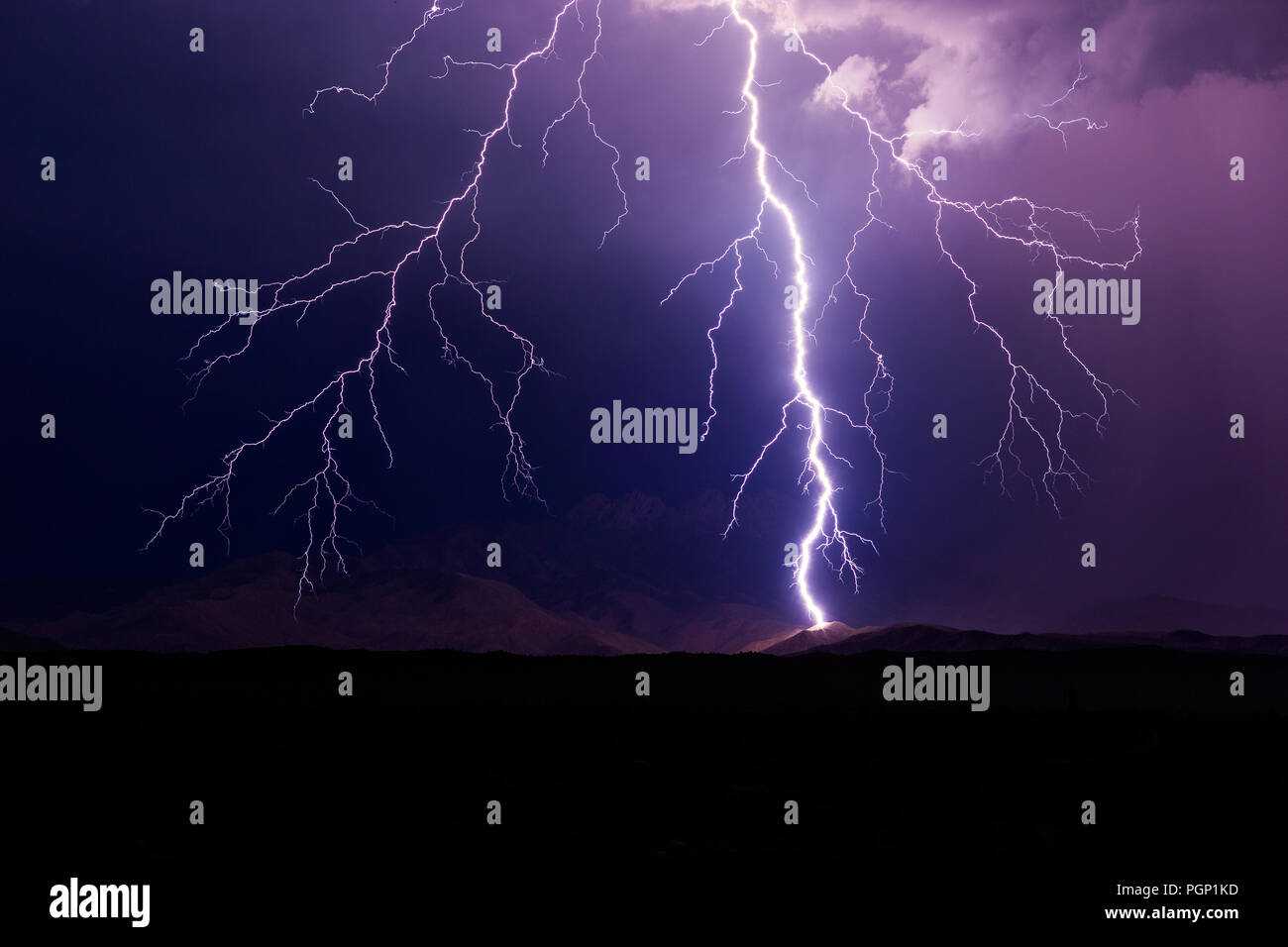 Dramatic monsoon storm with a powerful lightning bolt striking a mountain near Four Peaks, Arizona Stock Photo