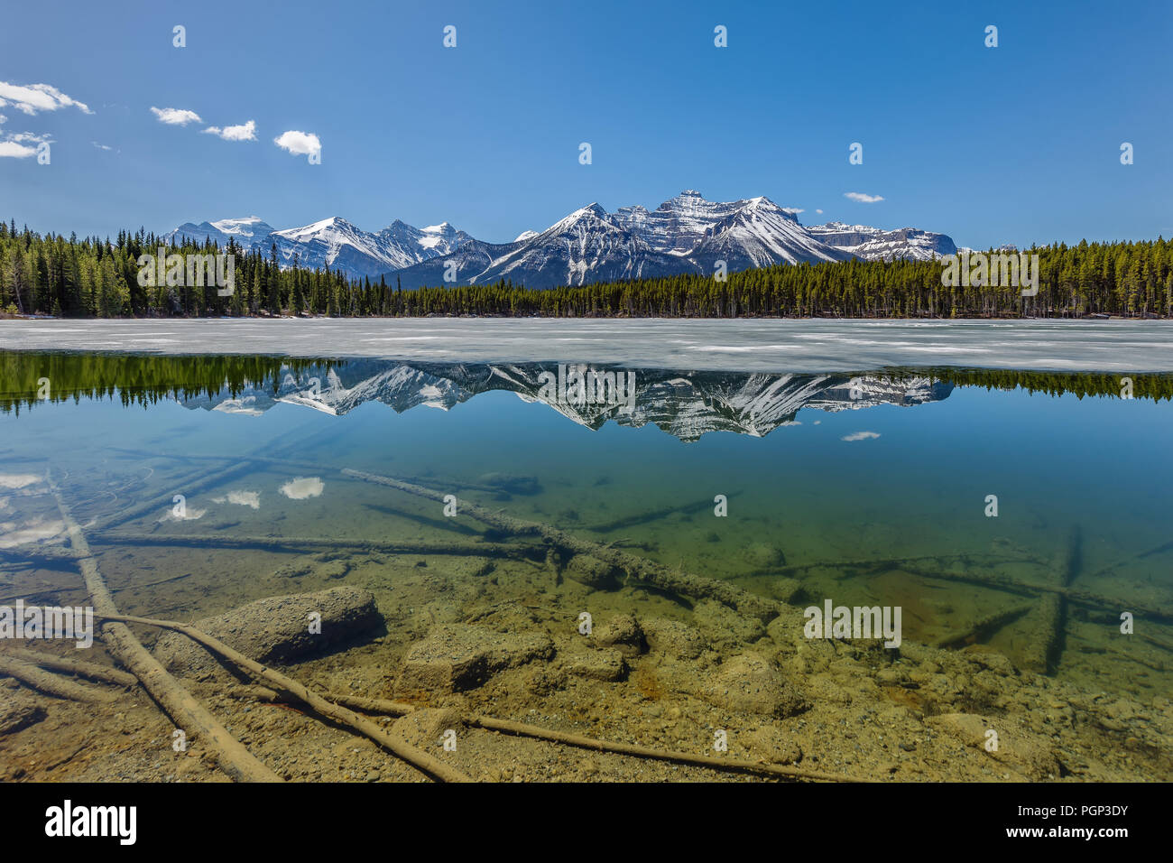 Reflection of the Canadian Rockies in Herbert Lake, the lake was still half frozen over. Stock Photo