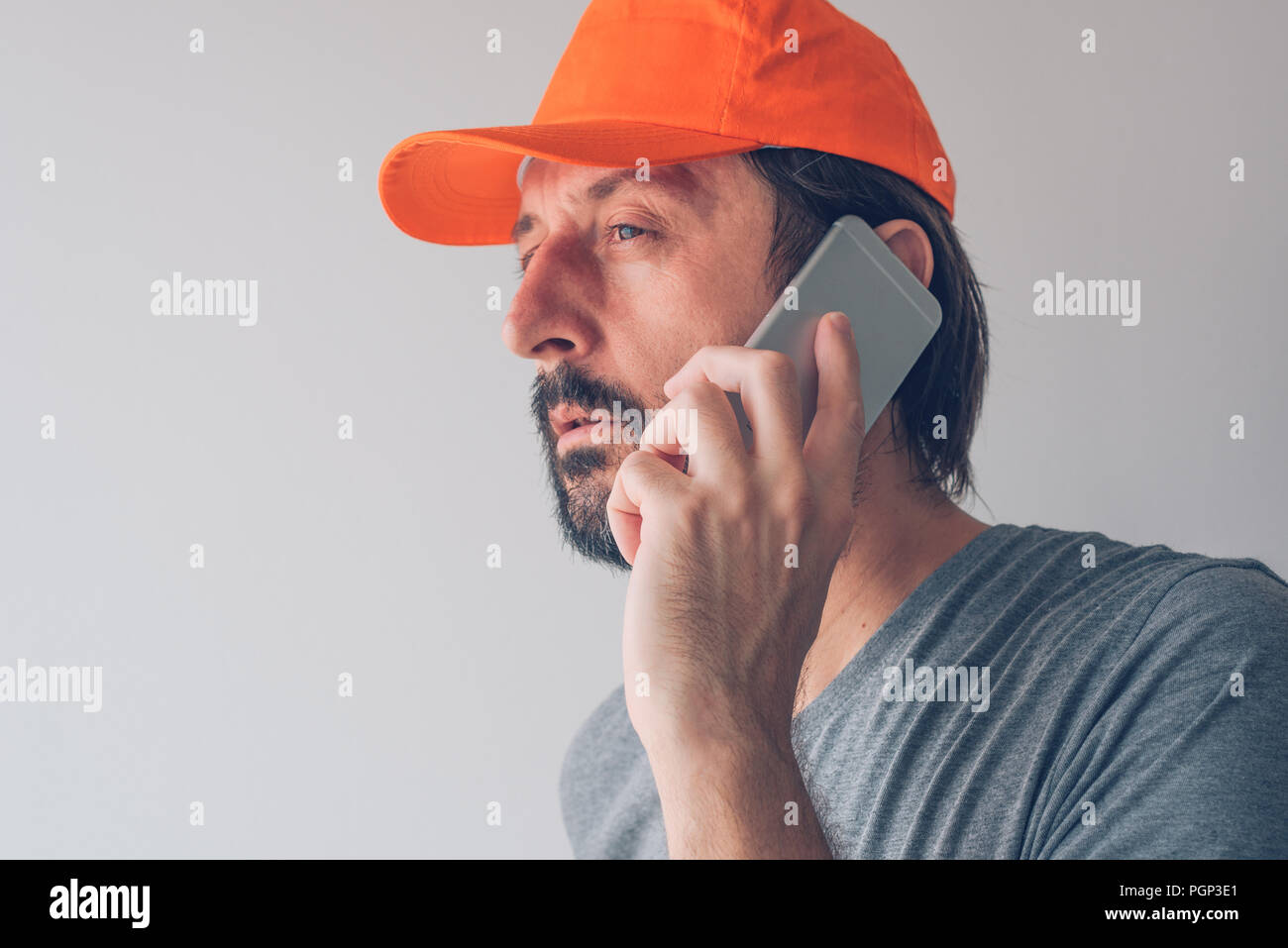 Man with baseball cap talking on smartphone, communication and connectivity concept Stock Photo