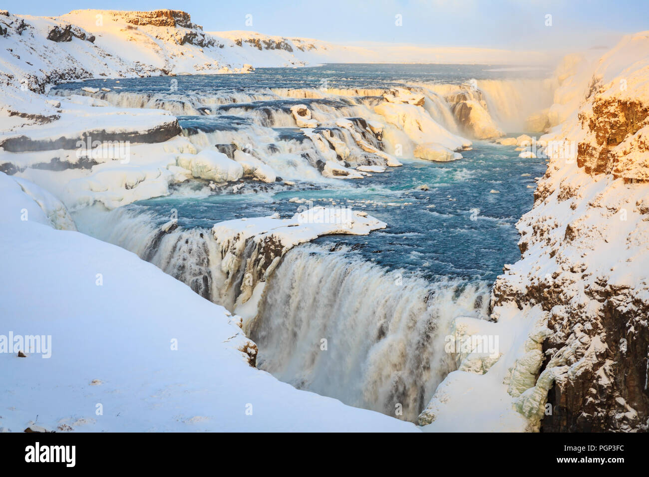 Gullfoss waterfalls located along the golden circle route, Iceland during Winter season. Ice, snow, water and sunset. Stock Photo