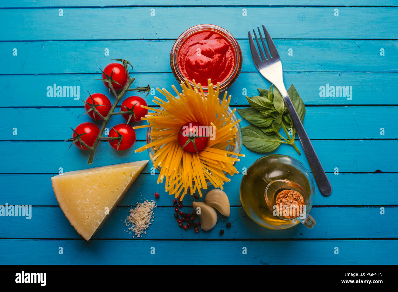 Pasta with various ingredients for cooking Italian food, on a blue