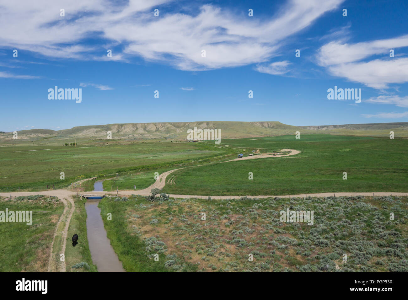 Dirt road and bridge cross an irrigation canal in the state of Wyoming in the American west. Stock Photo