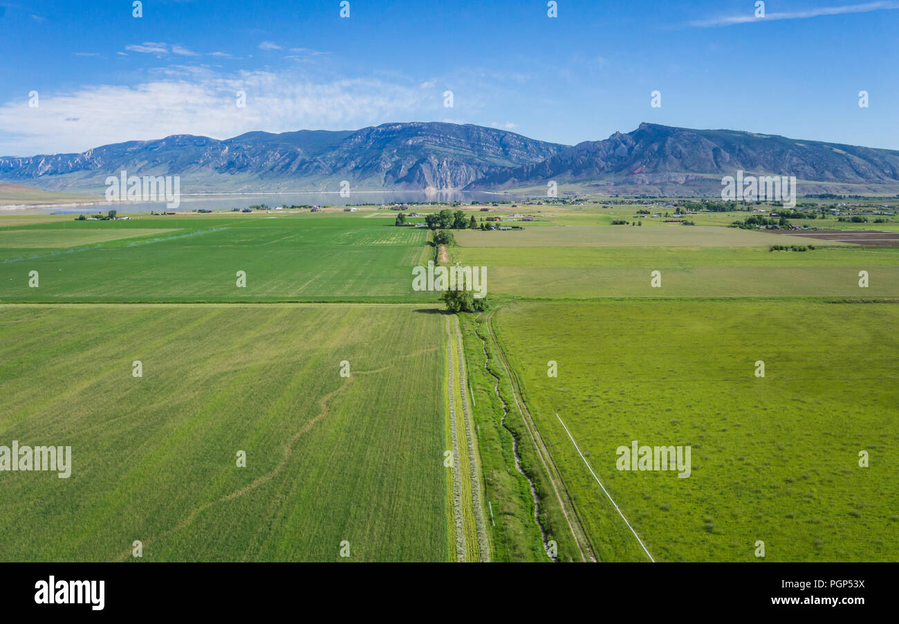 Green Wyoming farms and fields beneath the heights of the Rocky Mountains. Stock Photo
