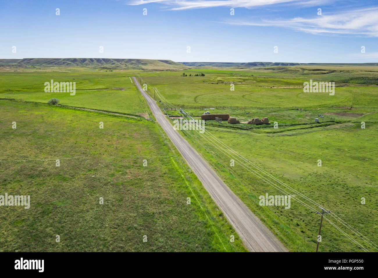 Narrow lane leads between the fields of a farm in the American west. Stock Photo