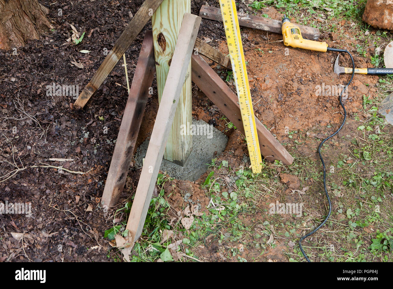 Wood fence post setting in concrete - USA Stock Photo