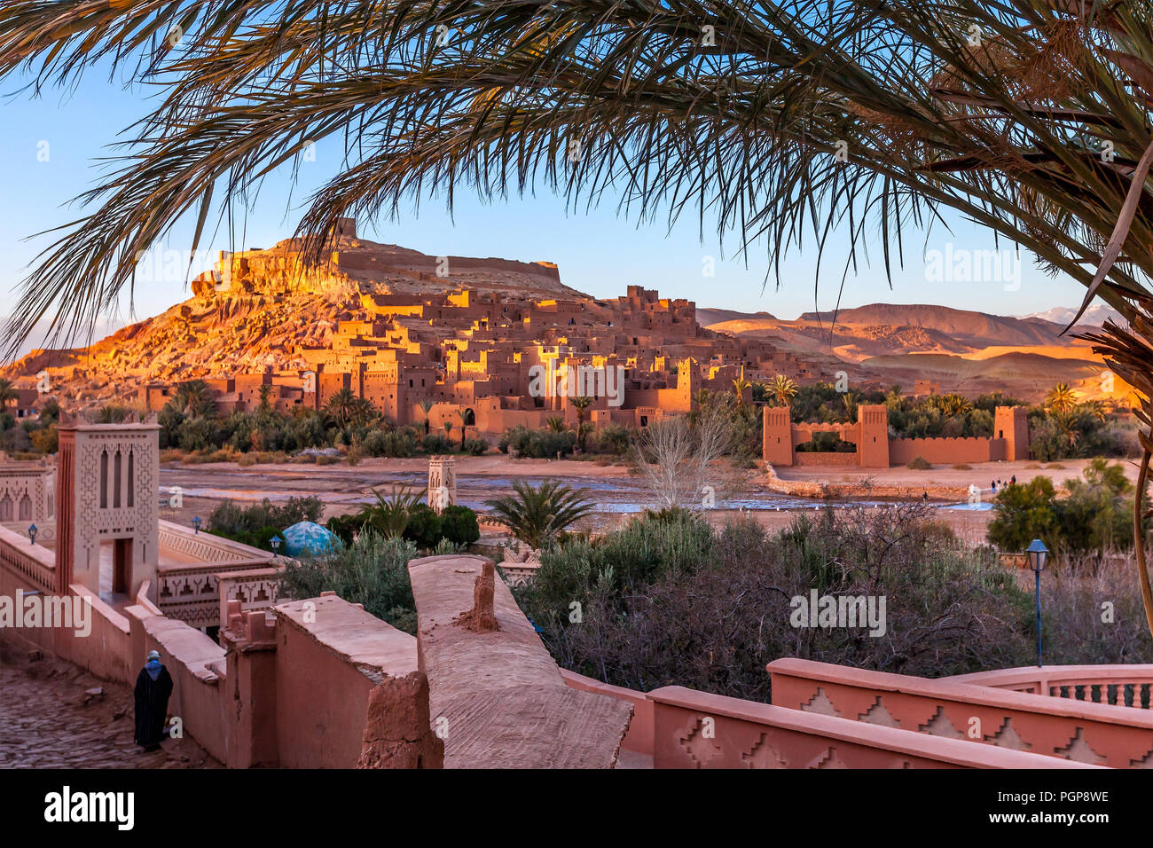 Morocco view of famous kasbah framed by palm tree fronds. Dozens of movies have been filmed at Ait Benhaddou, including scenes in Lawrence of Arabia. Stock Photo