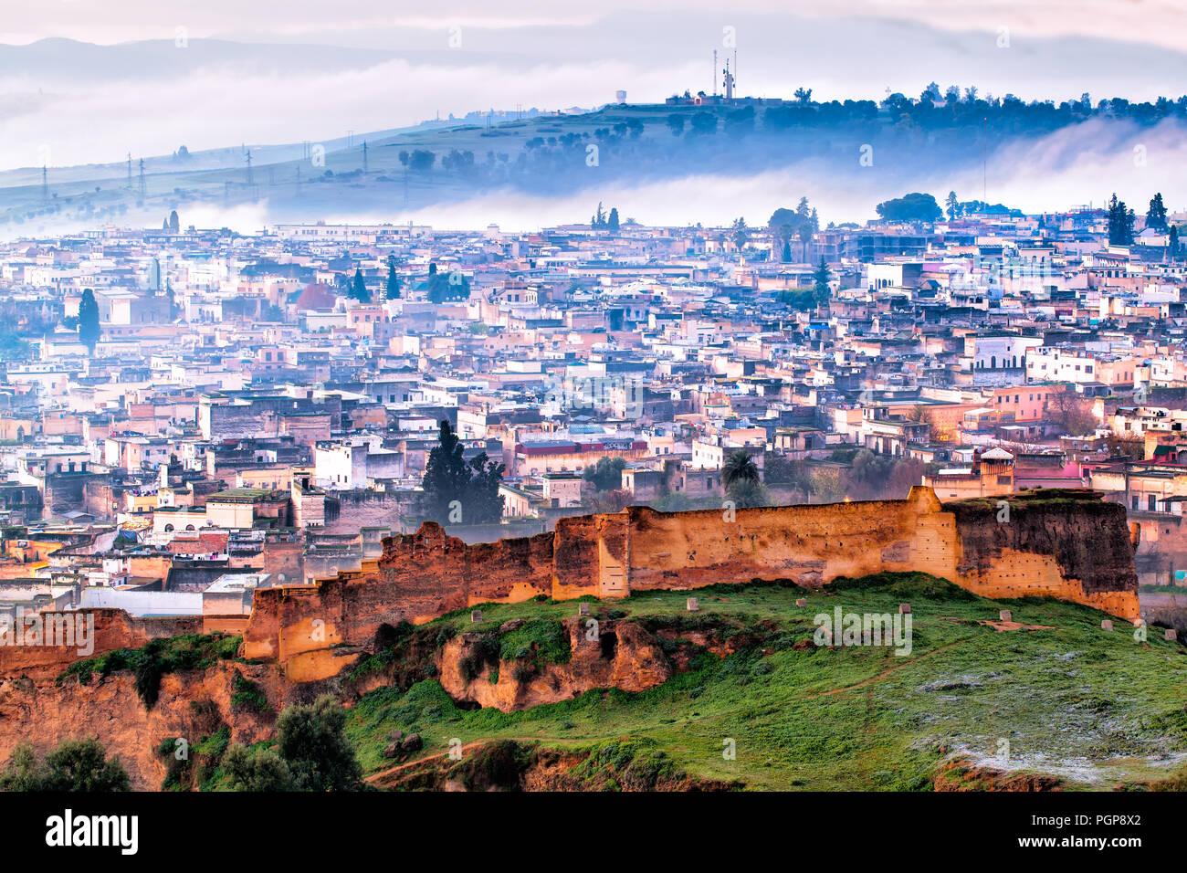 Morocco Fez aerial view over ancient fortified wall. Frosty winter day with fog rolling in. Atmospheric wide shot of this picturesque medieval city. Stock Photo