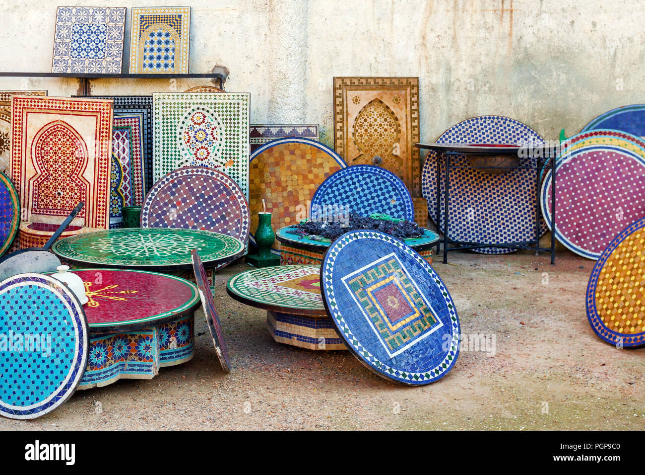 Morocco colorful tiled mosaic table tops and fountains displayed for sale at a large workshop in Fes, a center of fine Moroccan mosaic and pottery. Stock Photo