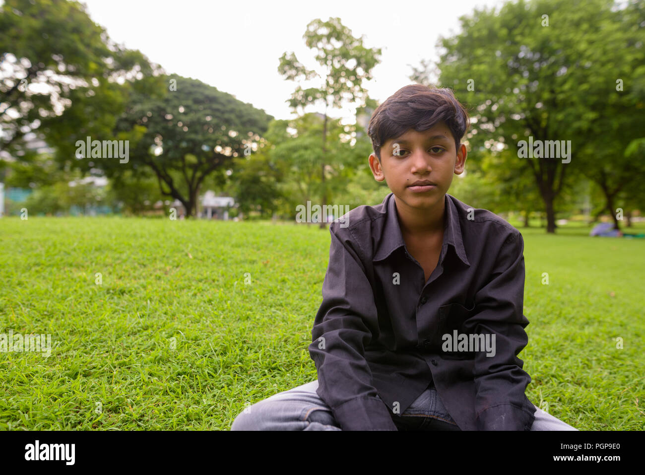 Portrait of young Indian boy relaxing at the park Stock Photo