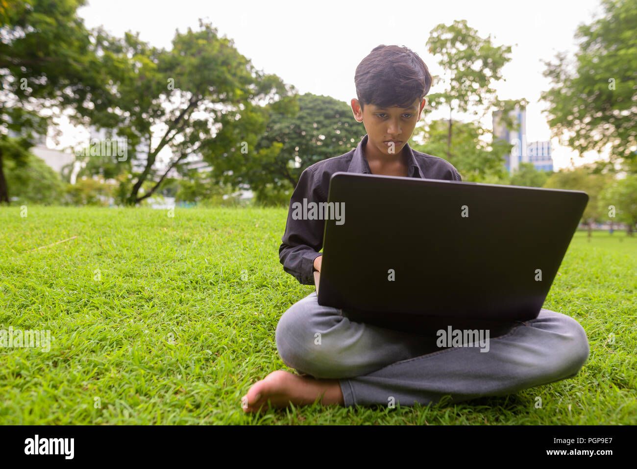 Portrait of young Indian boy relaxing at the park Stock Photo