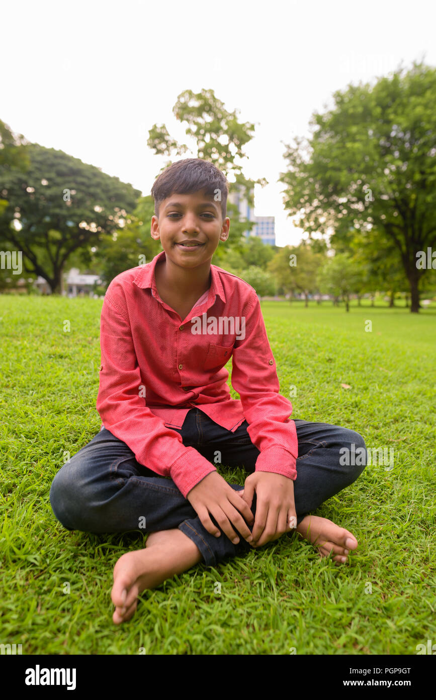 Portrait of young Indian boy relaxing at the park Stock Photo