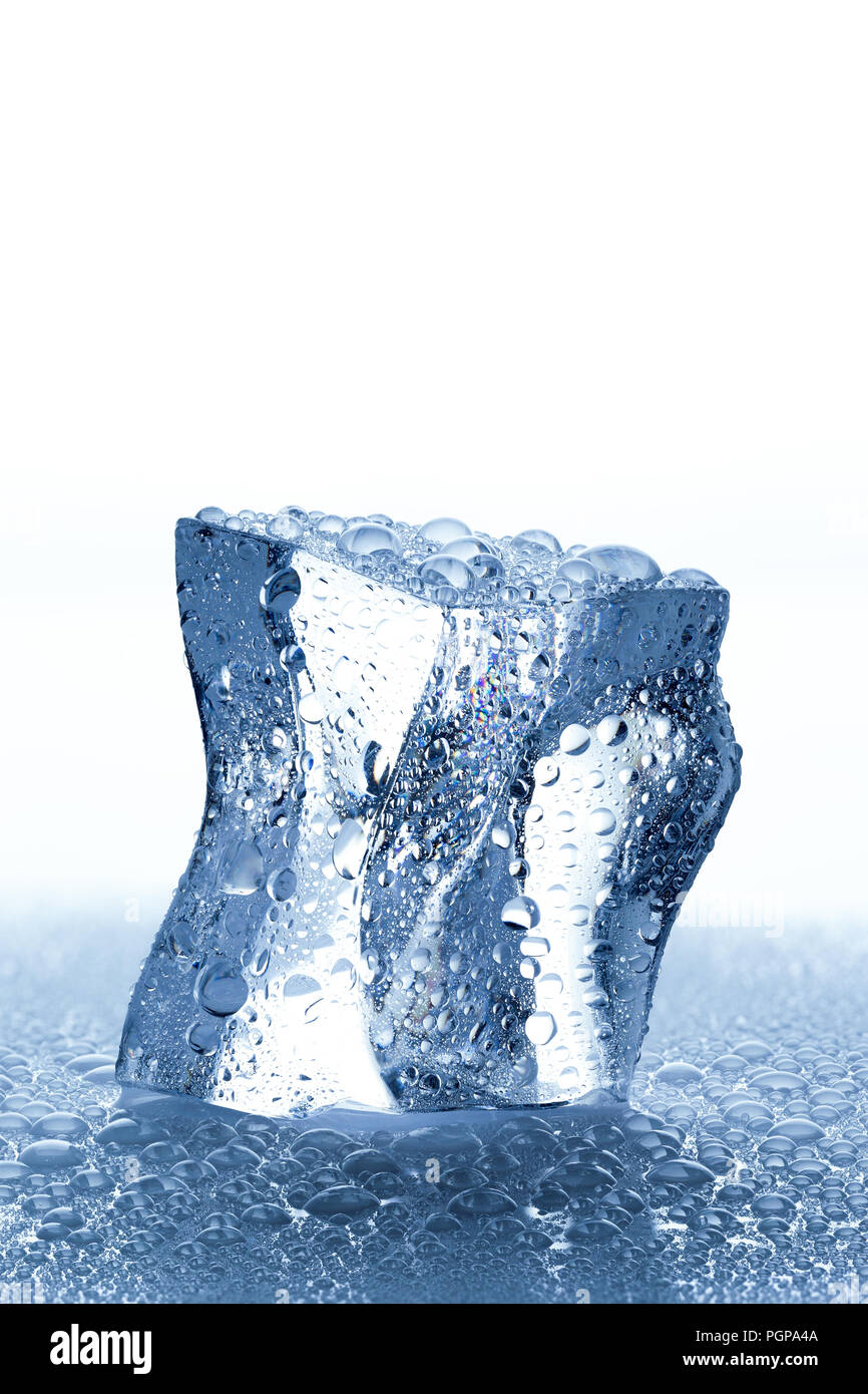 Single ice cube with water drops melting on wet white background Stock Photo