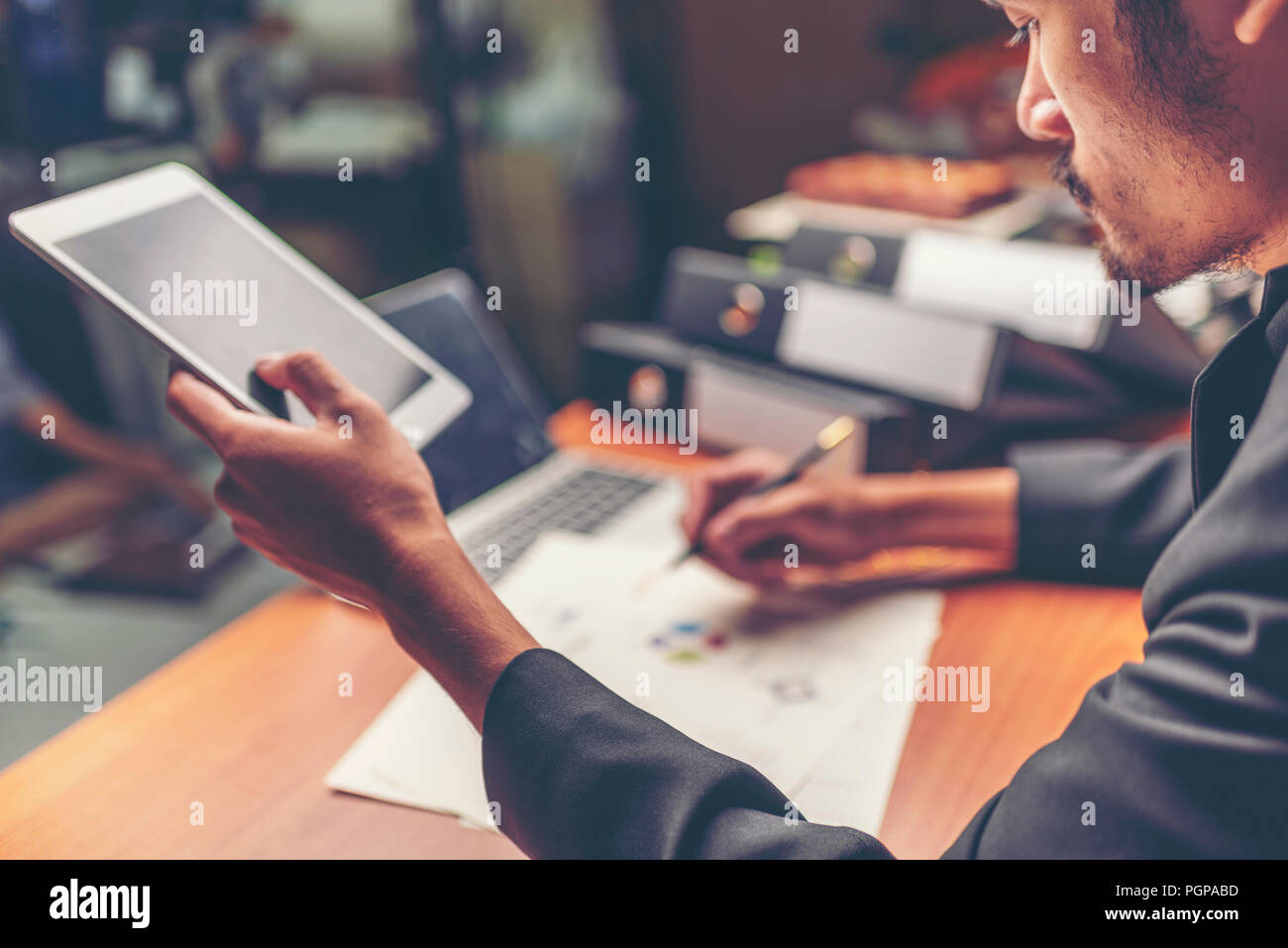 Businessmen are analyzed data from report using smartphone and laptop computer. Stock Photo