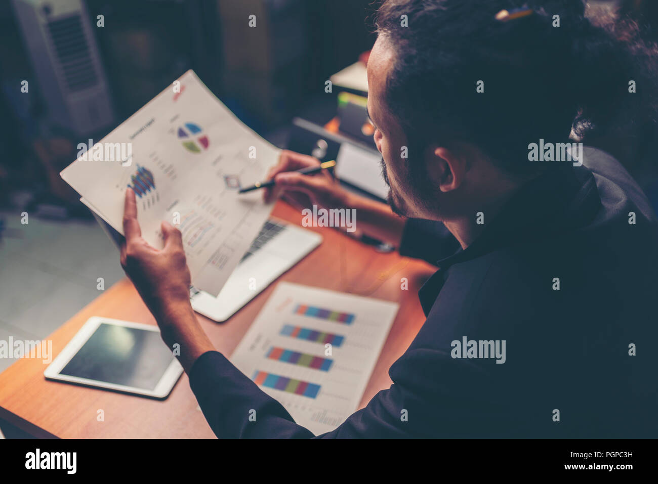 Businessmen are analyzed data from report using smartphone and laptop computer. Stock Photo