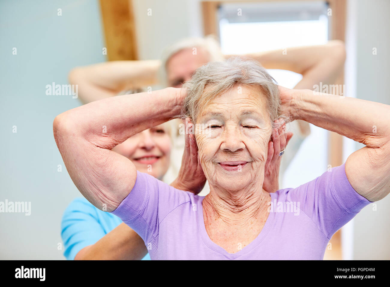 Trainer pays attention to proper execution of physiotherapy exercise ...
