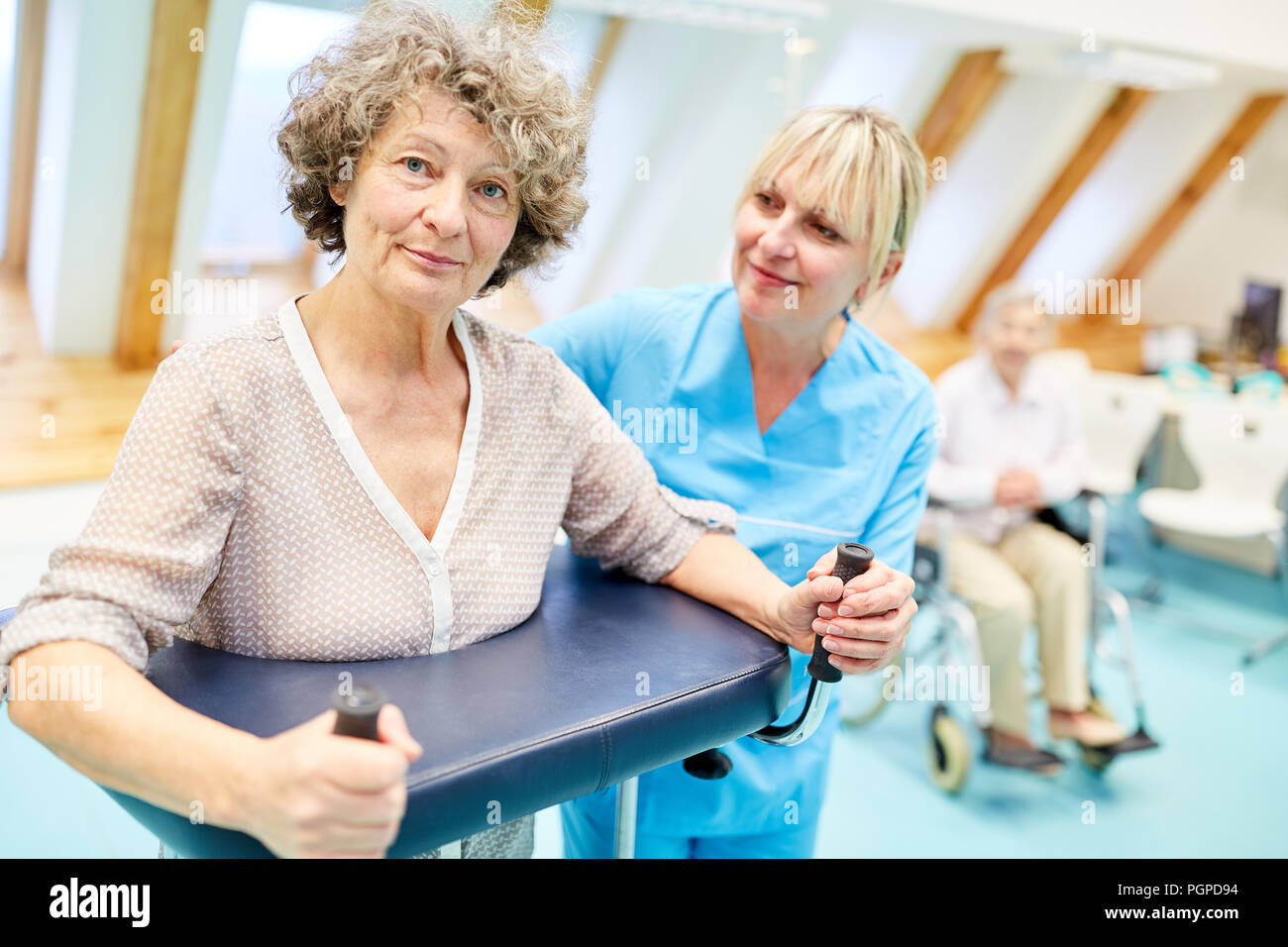 Senior woman as a patient with walker makes a rehab cared for in