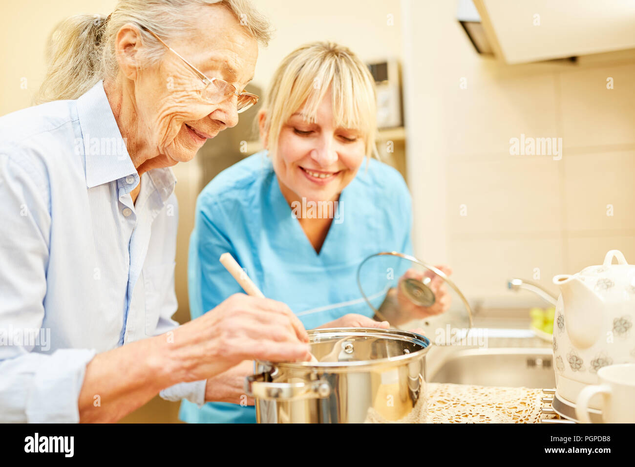 Nursing wife and senior citizen in the kitchen while cooking in