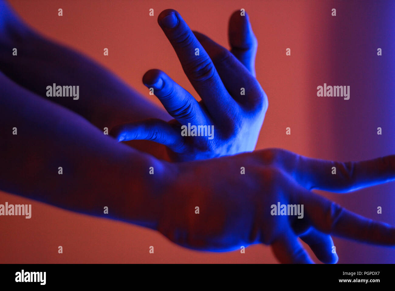 Human hands in red and blue color neon fluorescent light Stock Photo