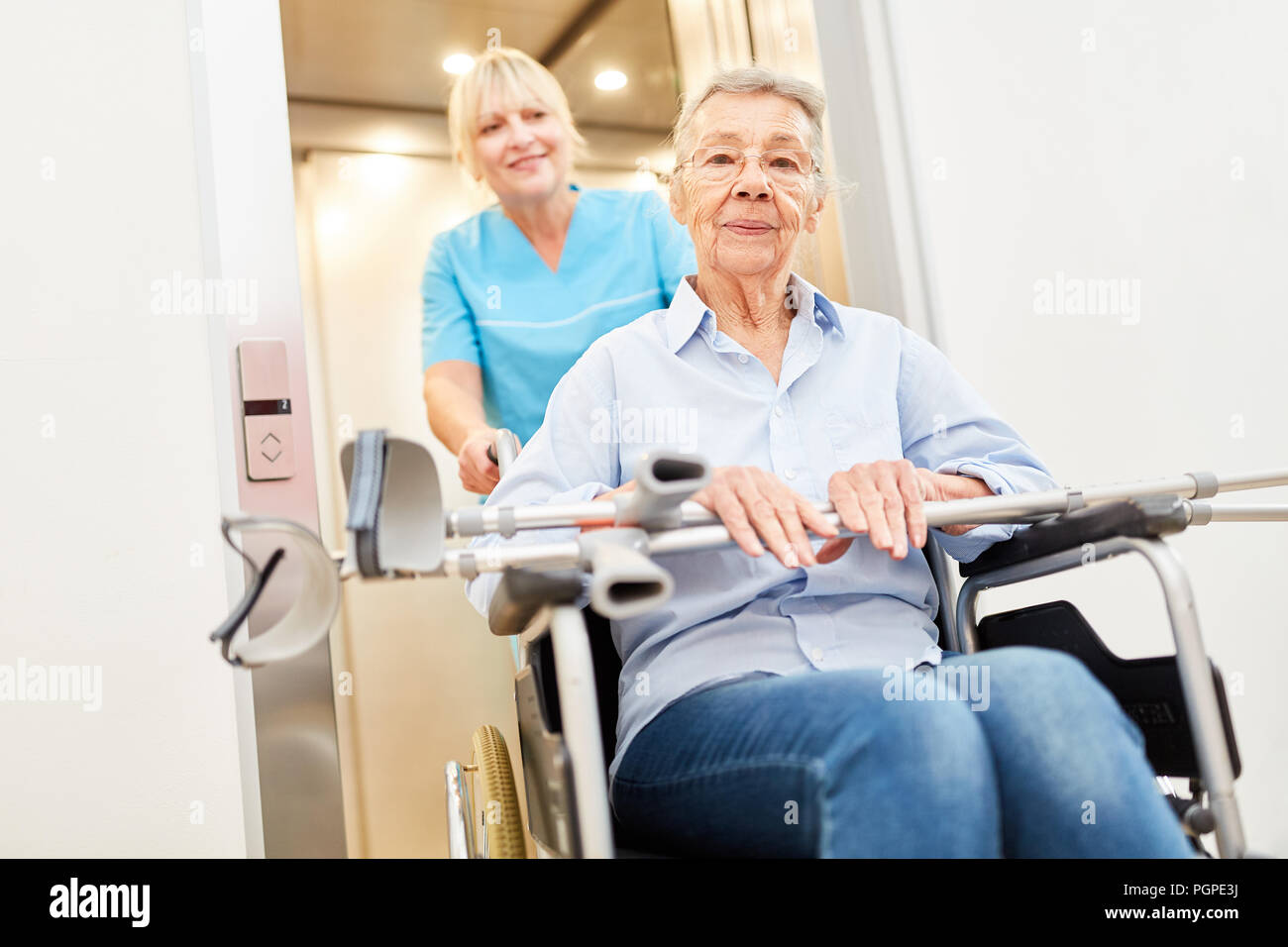 Old woman after stroke in a wheelchair at the elevator in nursing home