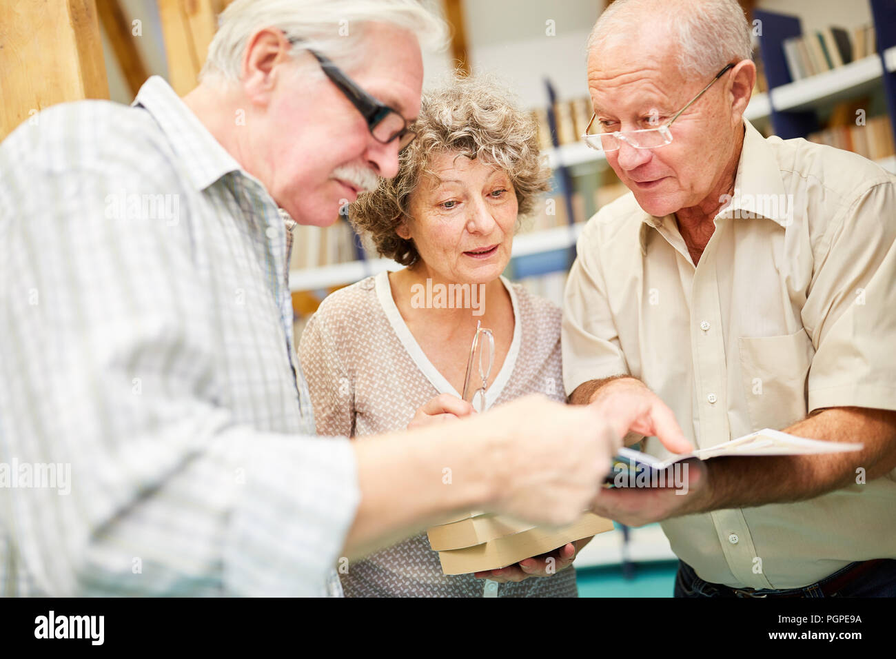 Group of seniors in the library in the retirement home reads books full ...