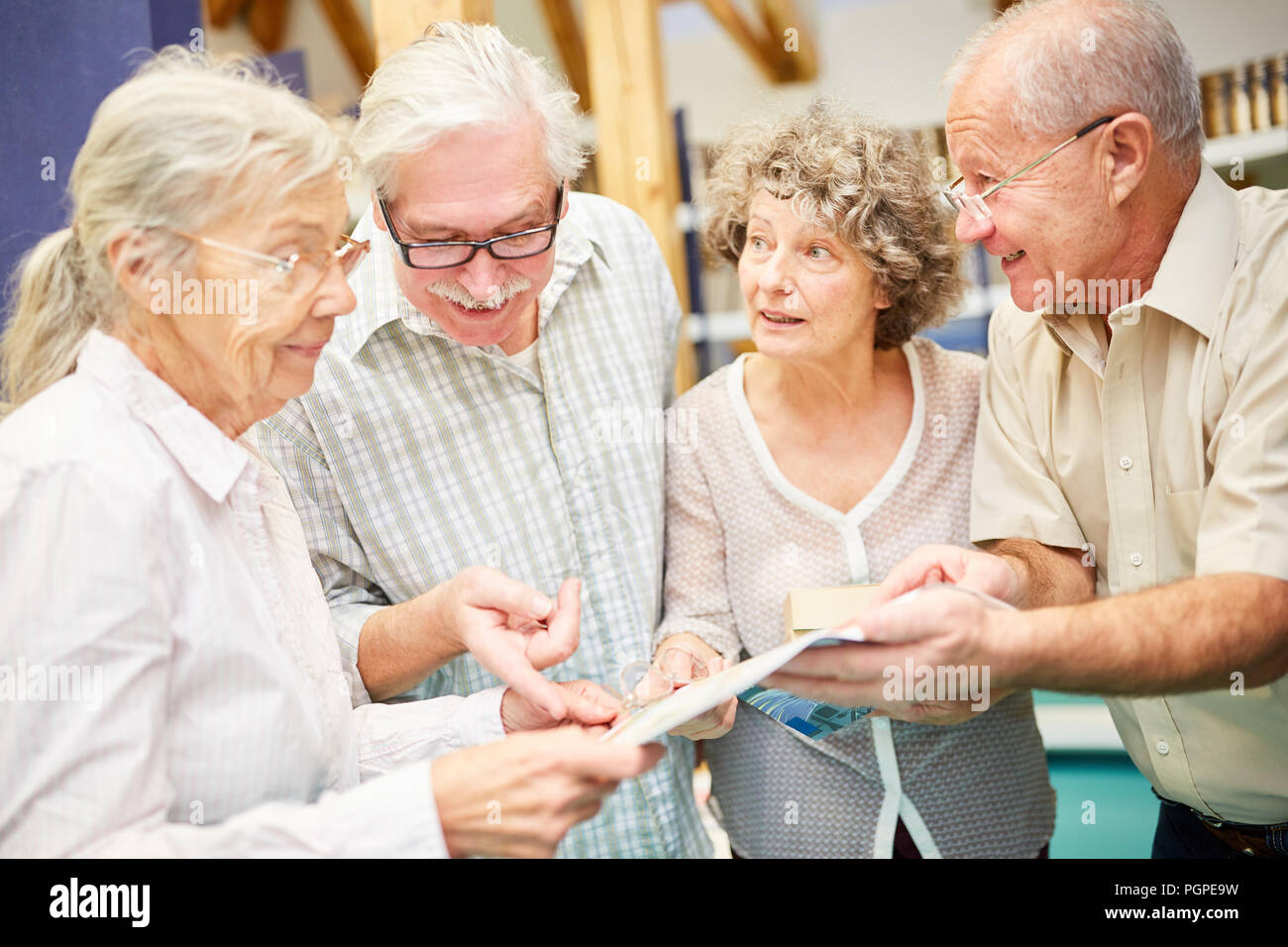 Senior group enjoys reading and learning with books in the library Stock Photo