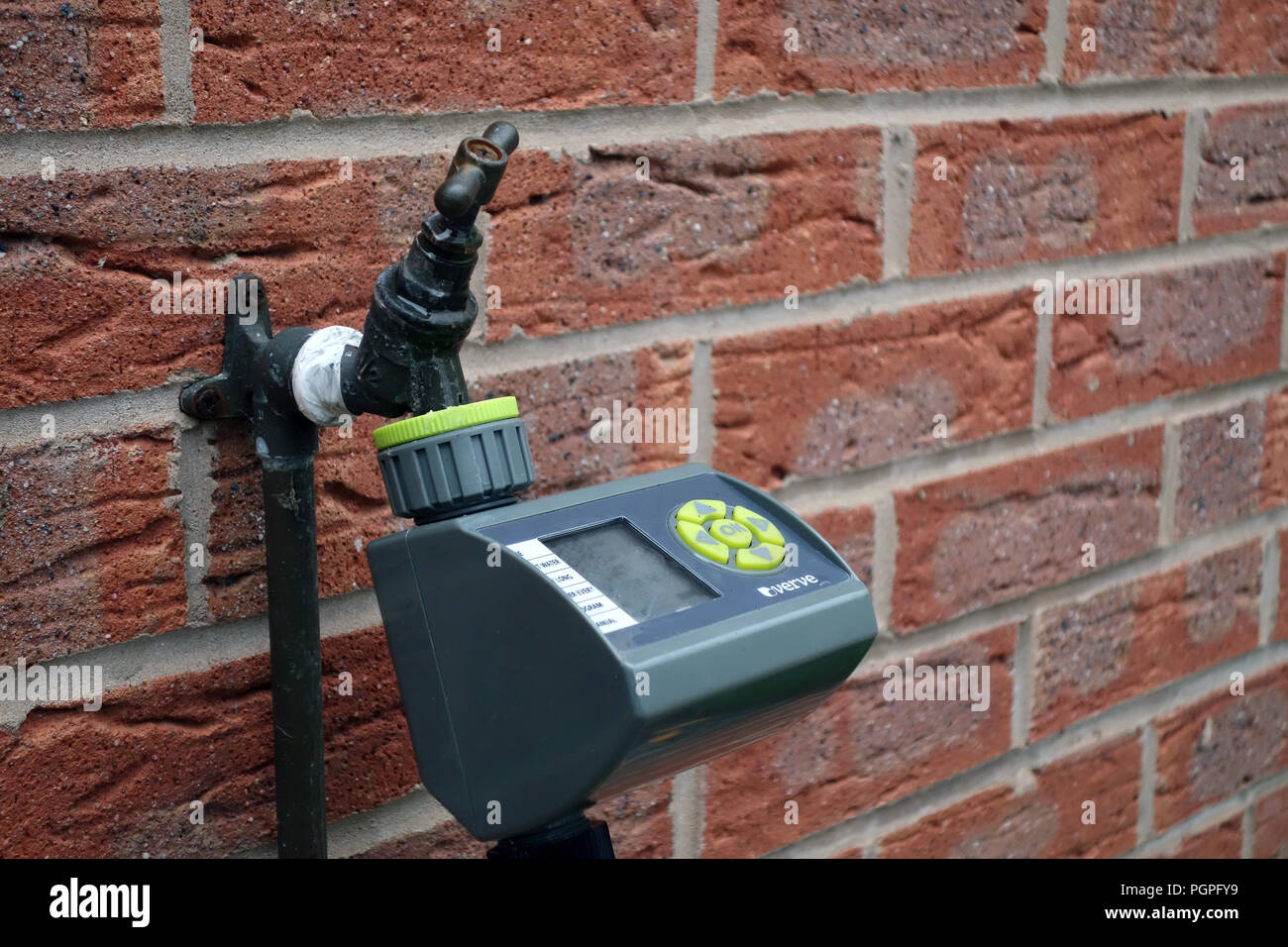 Automatic garden watering system control unit mounted on a wall in