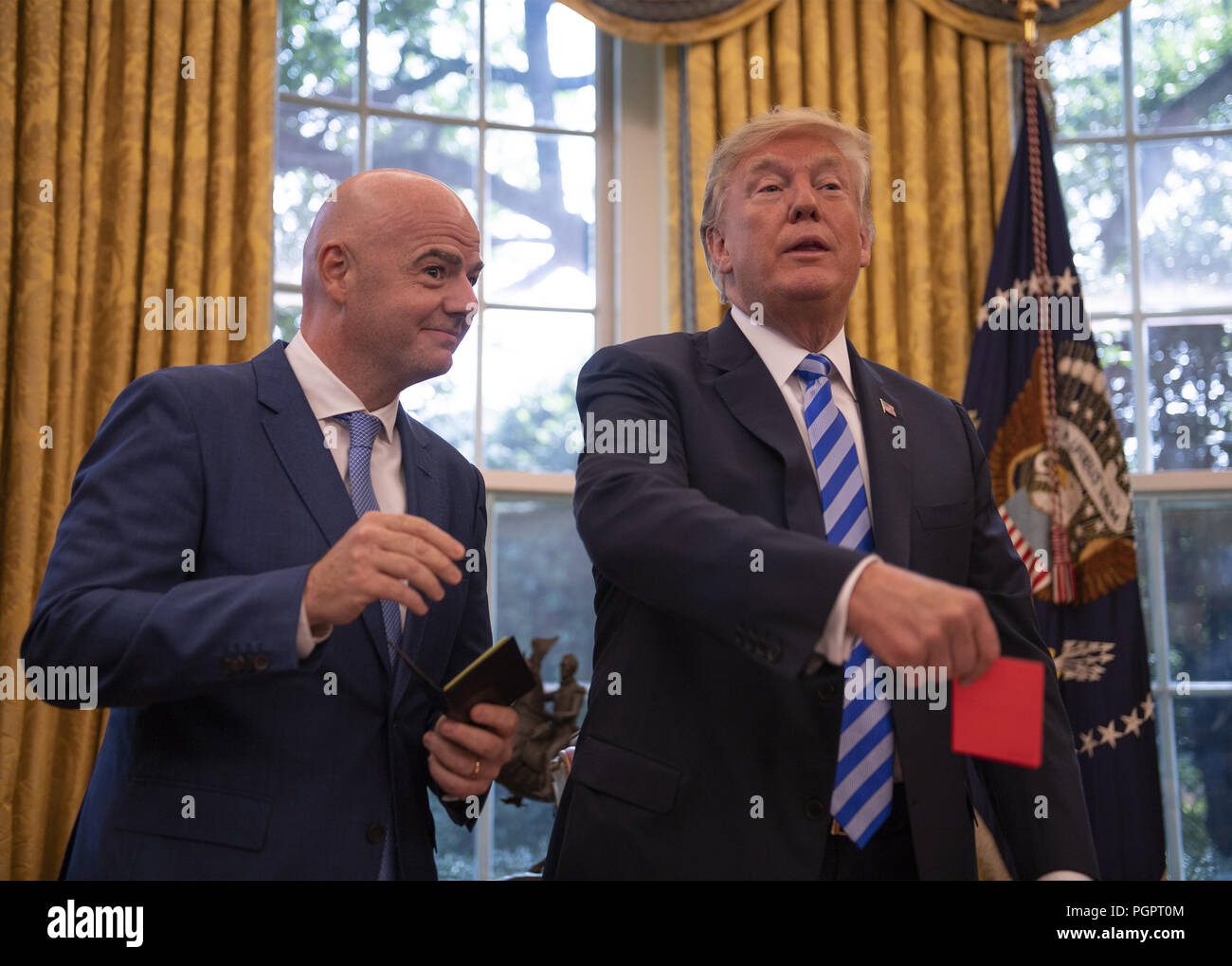 Washington, District of Columbia, USA. 28th Aug, 2018. United States President Donald J. Trump, right, holds a red penalty card that was presented to him by Gianni Infantino, left, President of Fédération Internationale de Football Association (FIFA) during a meeting to discuss the 2026 World Cup games in North America in the Oval Office of the White House in Washington, DC on Tuesday, August 28, 2018. FIFA describes itself as an international governing body of association football, futsal, and beach soccer Credit: Ron Sachs/CNP/ZUMA Wire/Alamy Live News Stock Photo