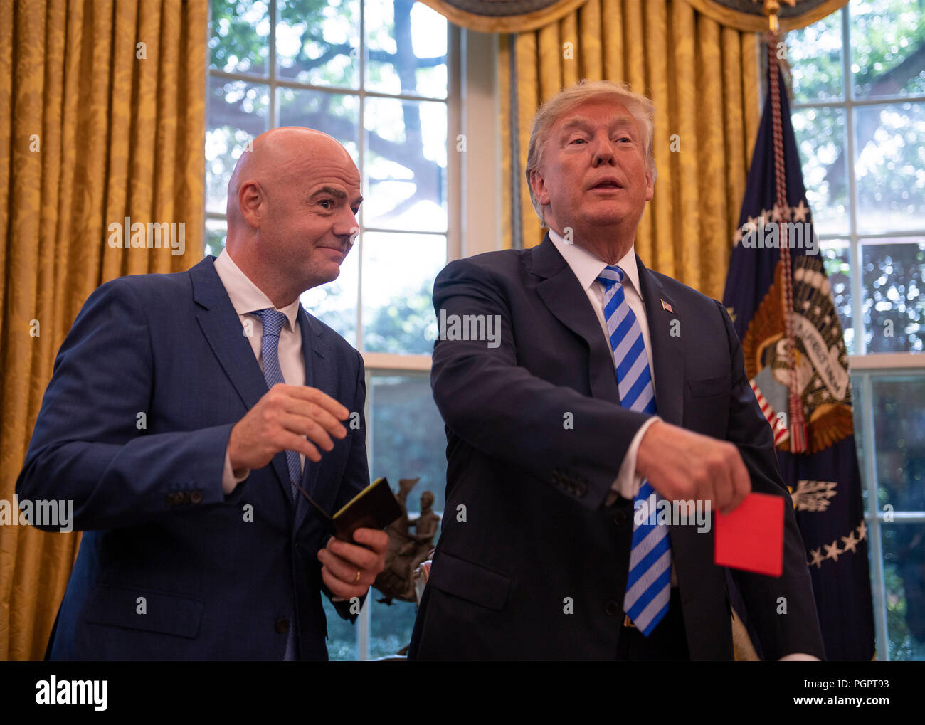 United States President Donald J. Trump, right, holds a red penalty card that was presented to him by Gianni Infantino, left, President of Fédération Internationale de Football Association (FIFA) during a meeting to discuss the 2026 World Cup games in North America in the Oval Office of the White House in Washington, DC on Tuesday, August 28, 2018. FIFA describes itself as an international governing body of association football, futsal, and beach soccer. Credit: Ron Sachs/CNP /MediaPunch Stock Photo