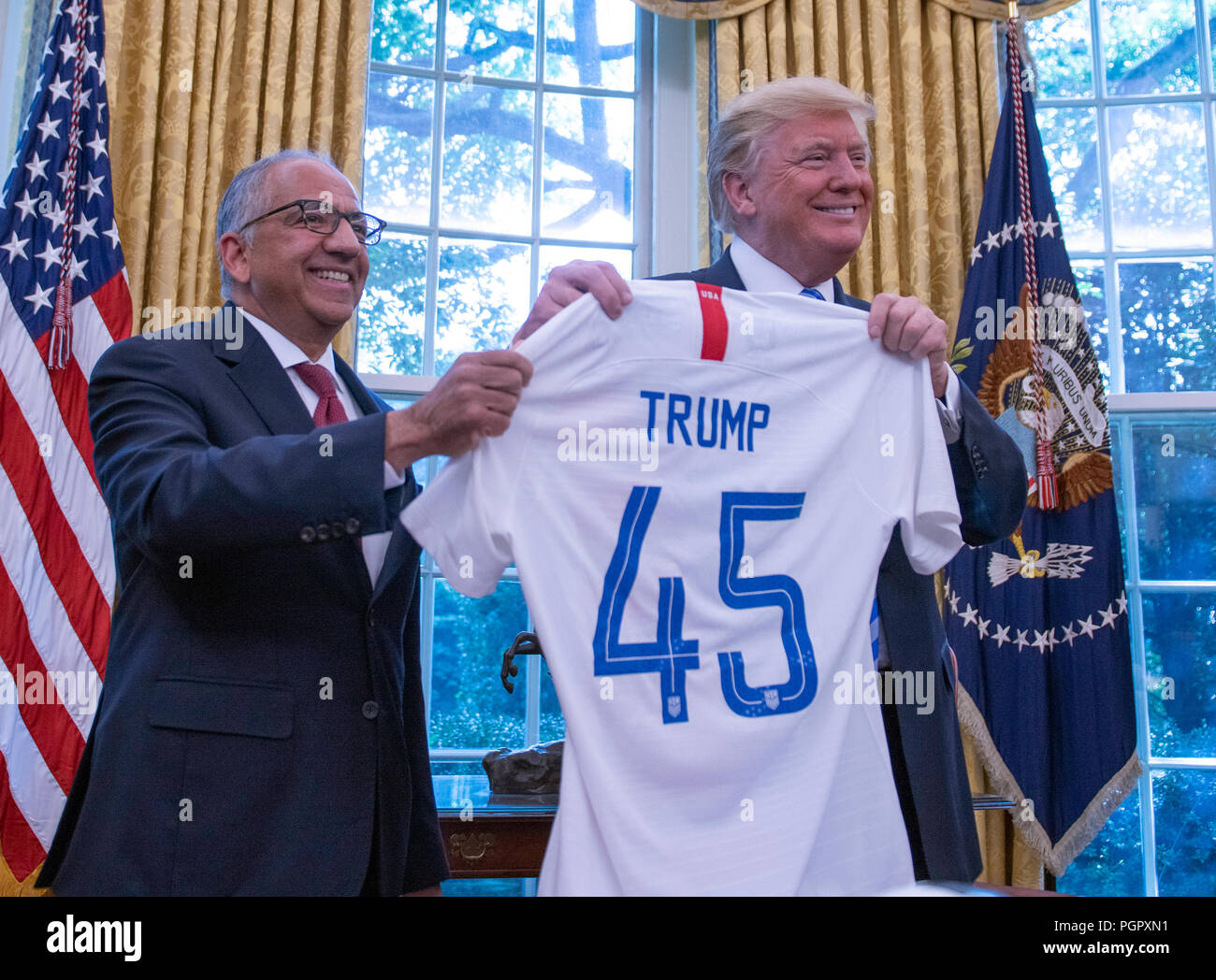 United States President Donald J. Trump and US Soccer President Carlos Cordeiro hold a soccer jersey in the Oval Office of the White House in Washington, DC on Tuesday, August 28, 2018. FIFA describes itself as an international governing body of association football, futsal, and beach soccer. Credit: Ron Sachs/CNP /MediaPunch Stock Photo