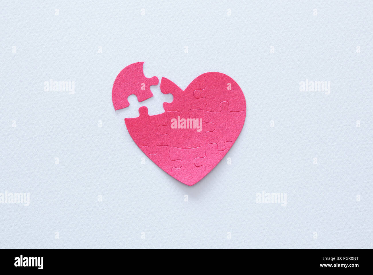 Top view image of paper pink heart puzzle with missing piece over white ...