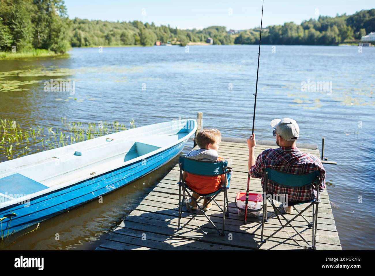 https://c8.alamy.com/comp/PGR7F8/father-and-son-sitting-on-chairs-on-the-pier-and-fishing-together-among-beautiful-nature-PGR7F8.jpg