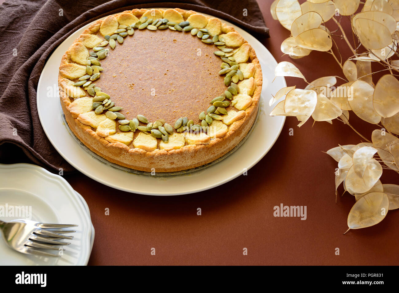 Homemade pumpkin pie with cinnamon on brown paper background. Thanksgiving day or halloween holiday concept Stock Photo