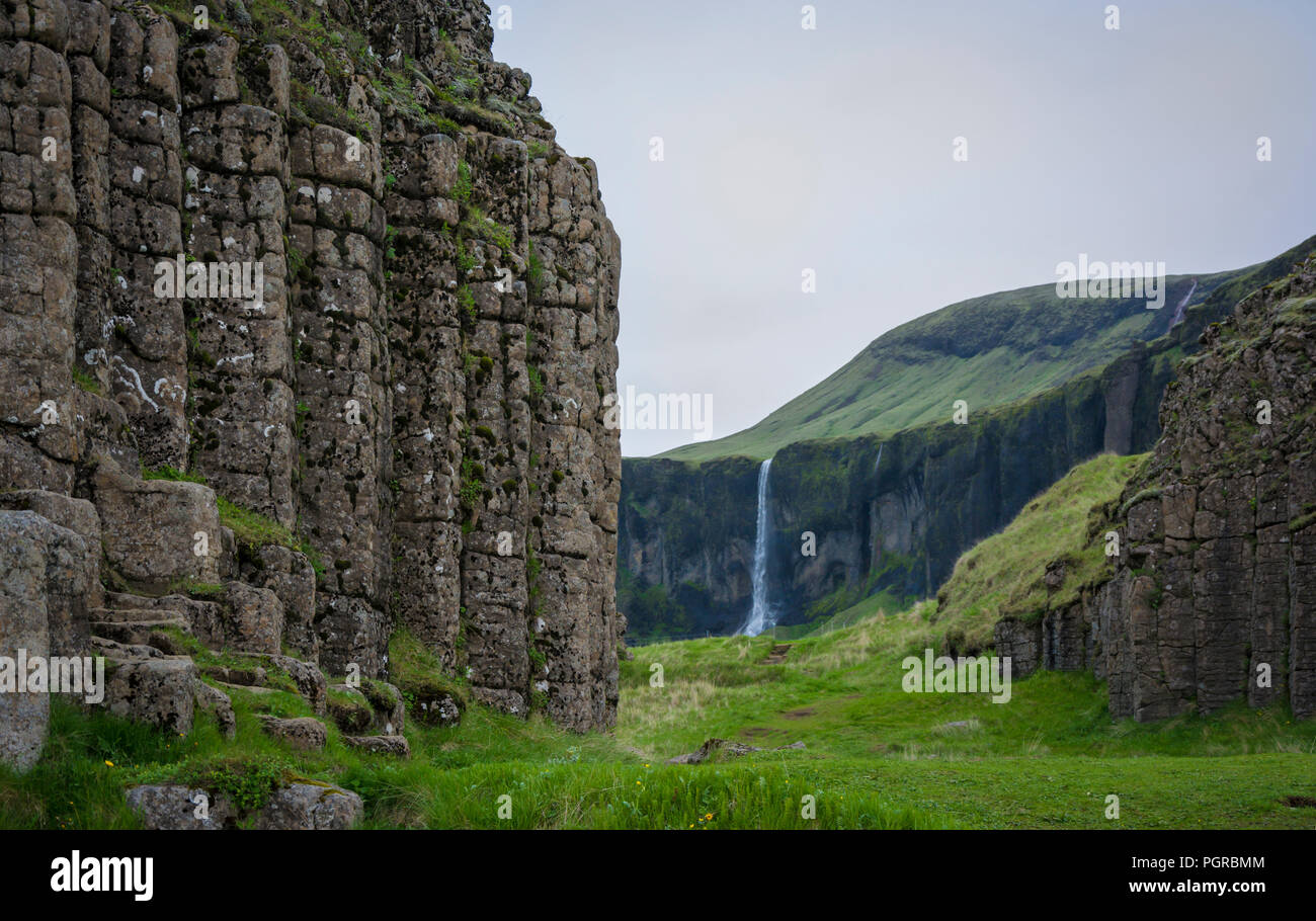 View through basalt columns to a waterfall at Dverghamrar or The Dwarf Cliffs in Iceland Stock Photo