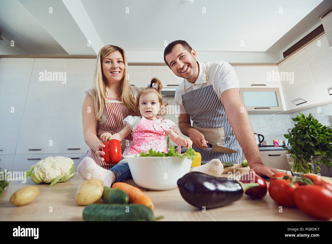 A happy family prepares food  in the kitchen. Stock Photo